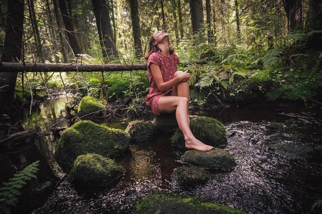 A woman stands barefoot in nature—a symbol of grounding and a return to balance