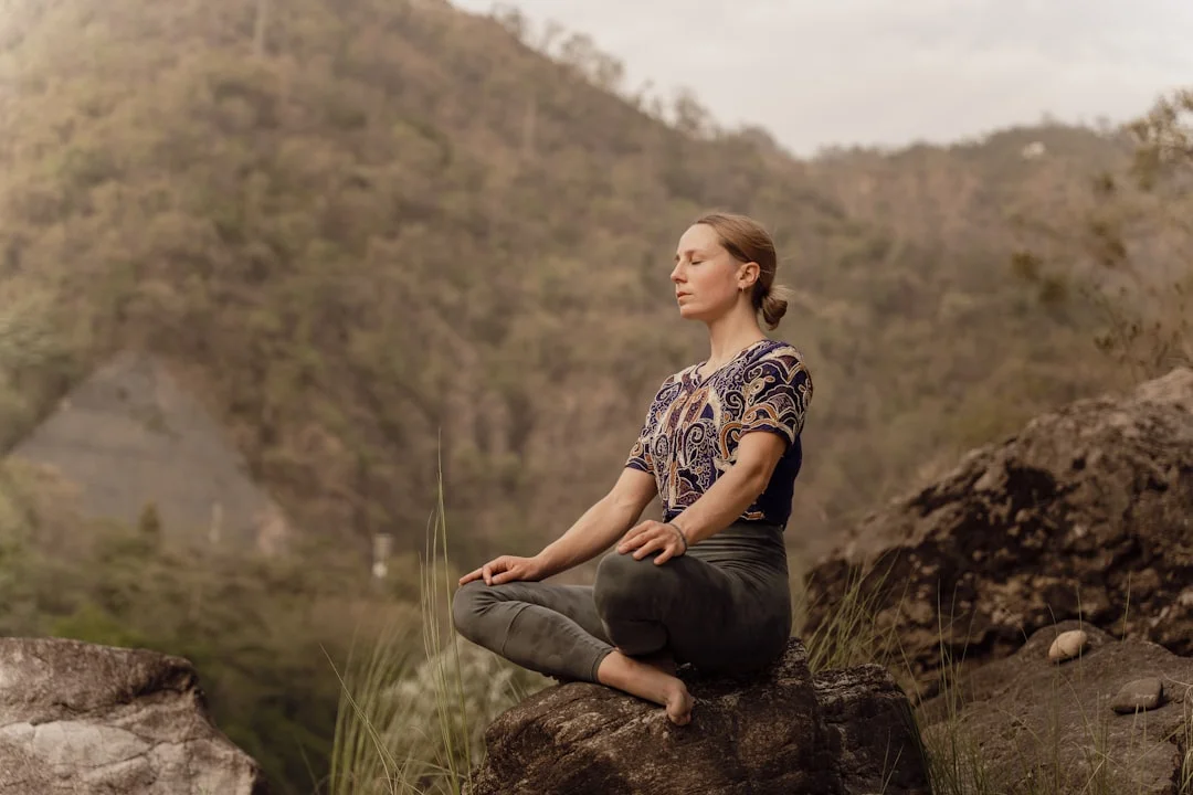 Femme assise tranquillement dans la nature en train de méditer - symbole de force mentale et de contrôle intérieur
