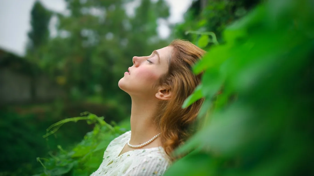Mujer relajada respirando profundamente en la naturaleza