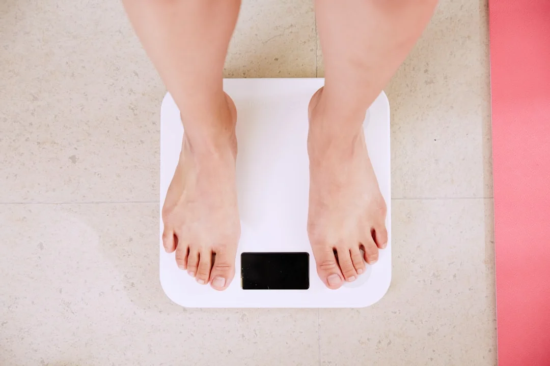 persona de pie sobre una balanza de baño digital blanca
