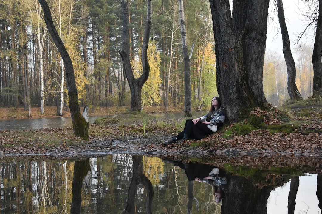Femme assise tranquillement dans la nature et réfléchissant - symbole de force intérieure et de facteurs de résilience