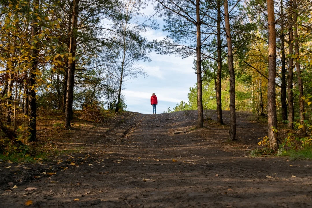 Frau geht entspannt durch einen herbstlichen Wald