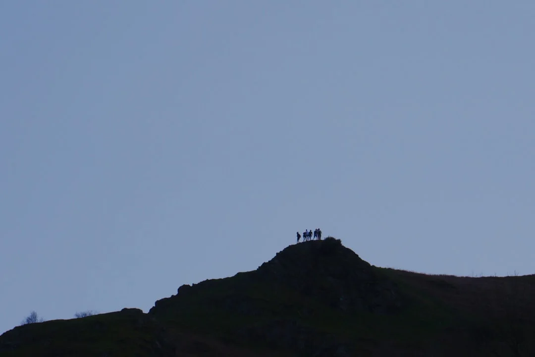 Una persona si trova sulla cima di una montagna e guarda in lontananza: successo e performance come parte del modello PERMA.