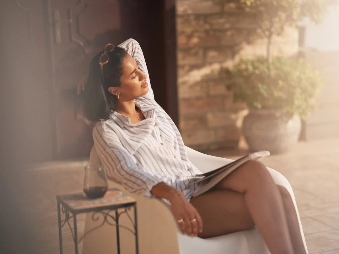 Une femme écrit tranquillement dans un carnet à la lumière du soleil - le journaling comme accès au travail intérieur