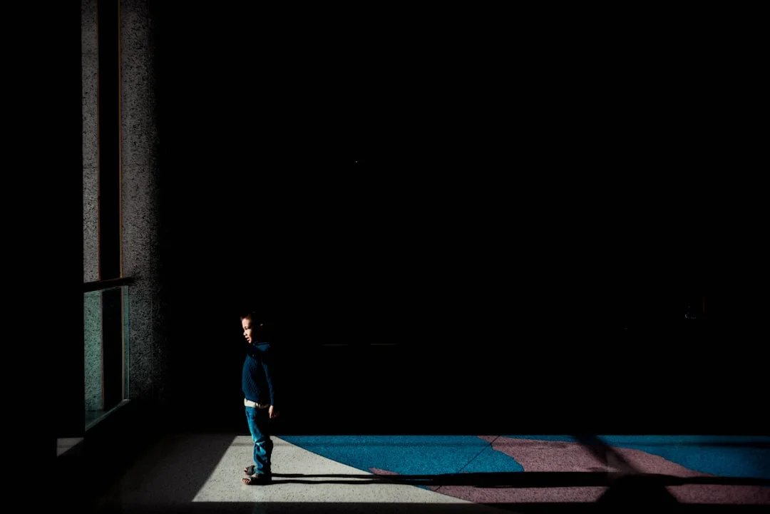 Un enfant regarde pensivement la lumière par une fenêtre - symbole de l'enfant intérieur