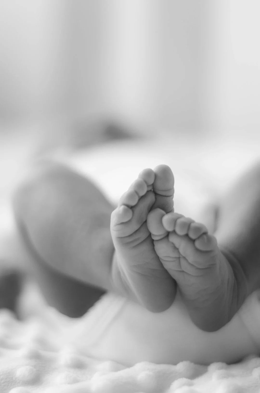 Foto en escala de grises de los pies de un bebé