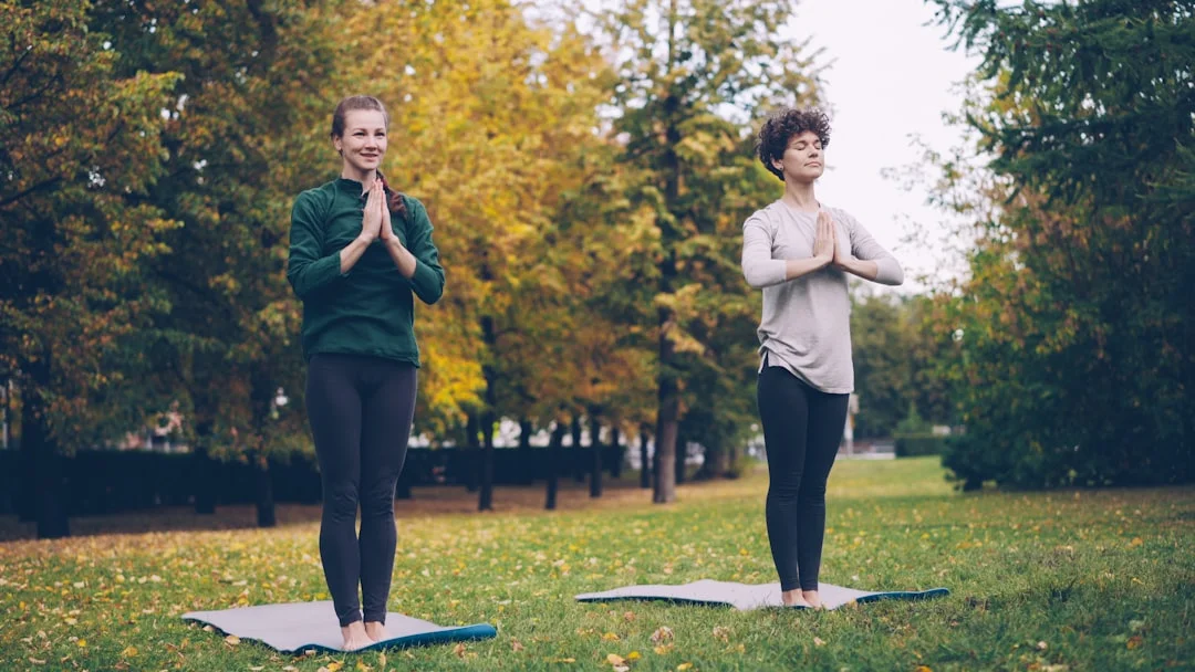 Mujer practicando yoga en la naturaleza, relajada y equilibrada