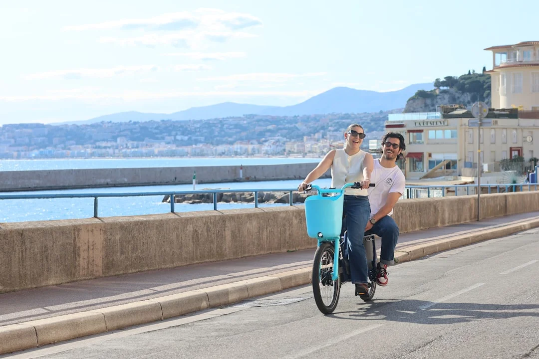 Coppia in sella a una bicicletta tandem in riva al mare