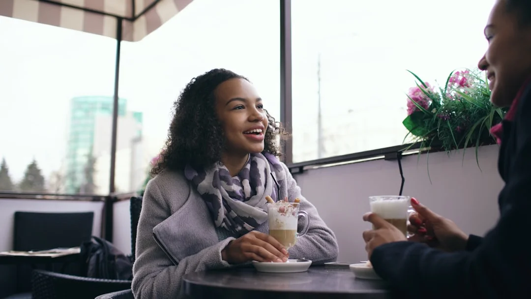 Dos mujeres conversando animadamente mientras toman un café