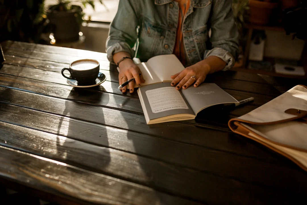 A woman writes thoughtfully in her diary in the morning light