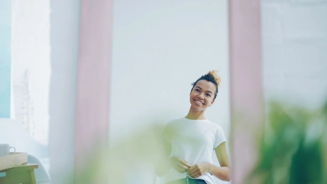 Woman smiles at herself in the mirror with self-confidence