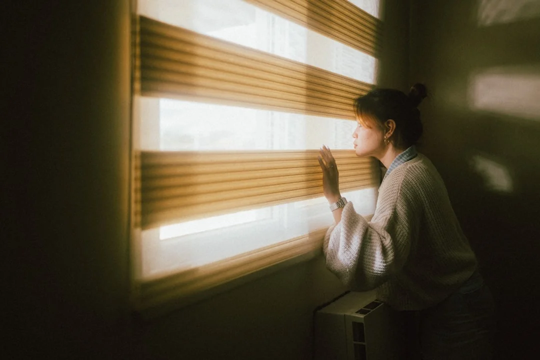 Una mujer se sienta tranquilamente ante la ventana y supera la tensión matinal