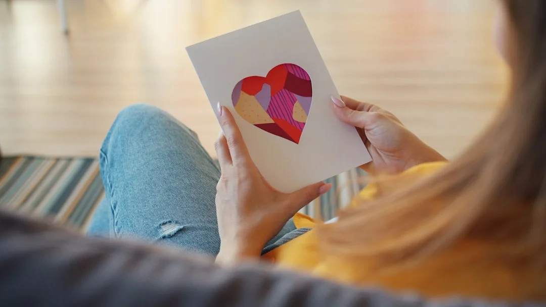 A woman reads a handwritten card of encouragement with a calm, pensive expression on her face