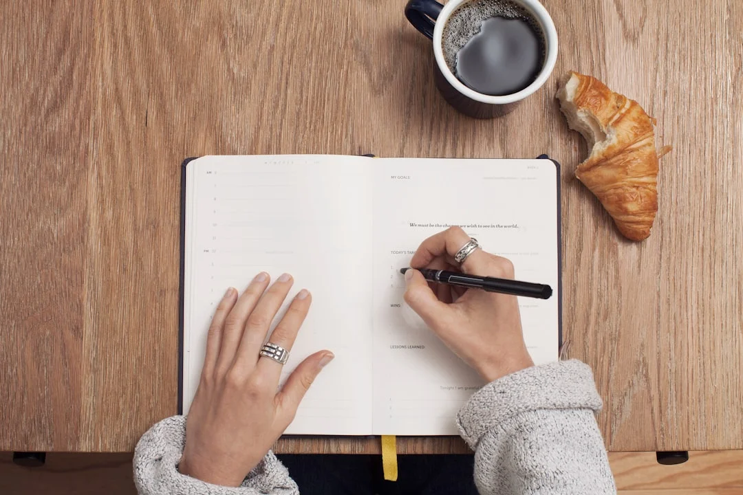 Una donna scrive nel suo diario al mattino, sorseggiando una tazza di tè