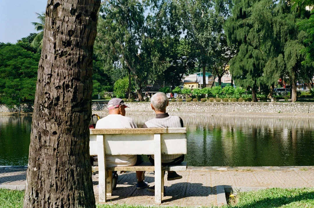Personne assise tranquillement sur un banc dans un parc entouré de nature