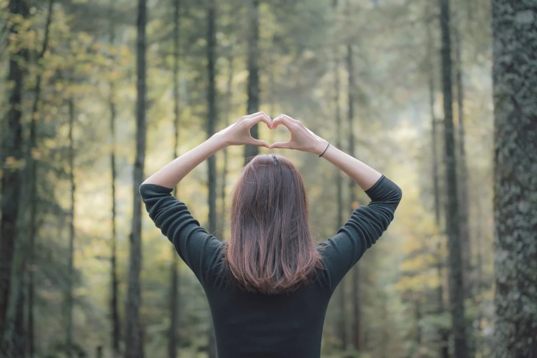 Una donna porta le mani al cuore in un momento di riflessione