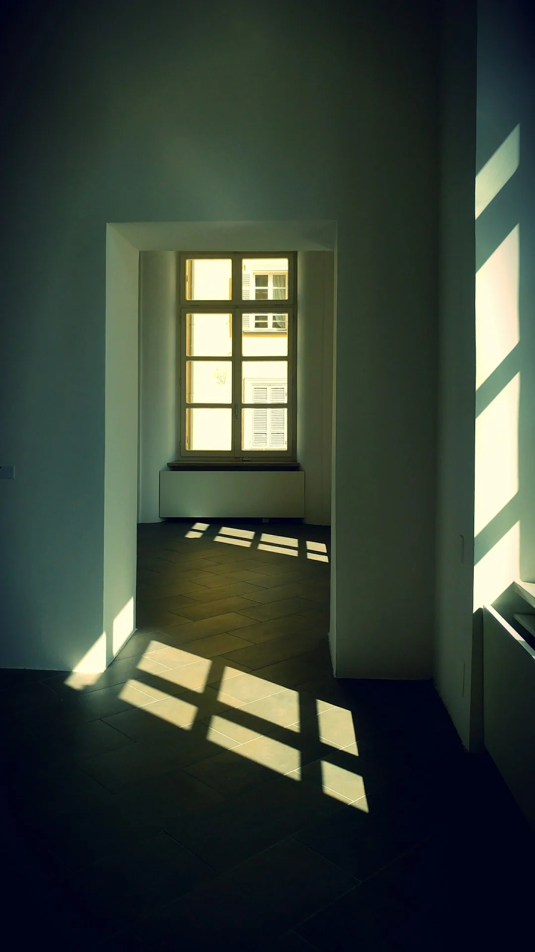 The sun is shining through the windows in the room