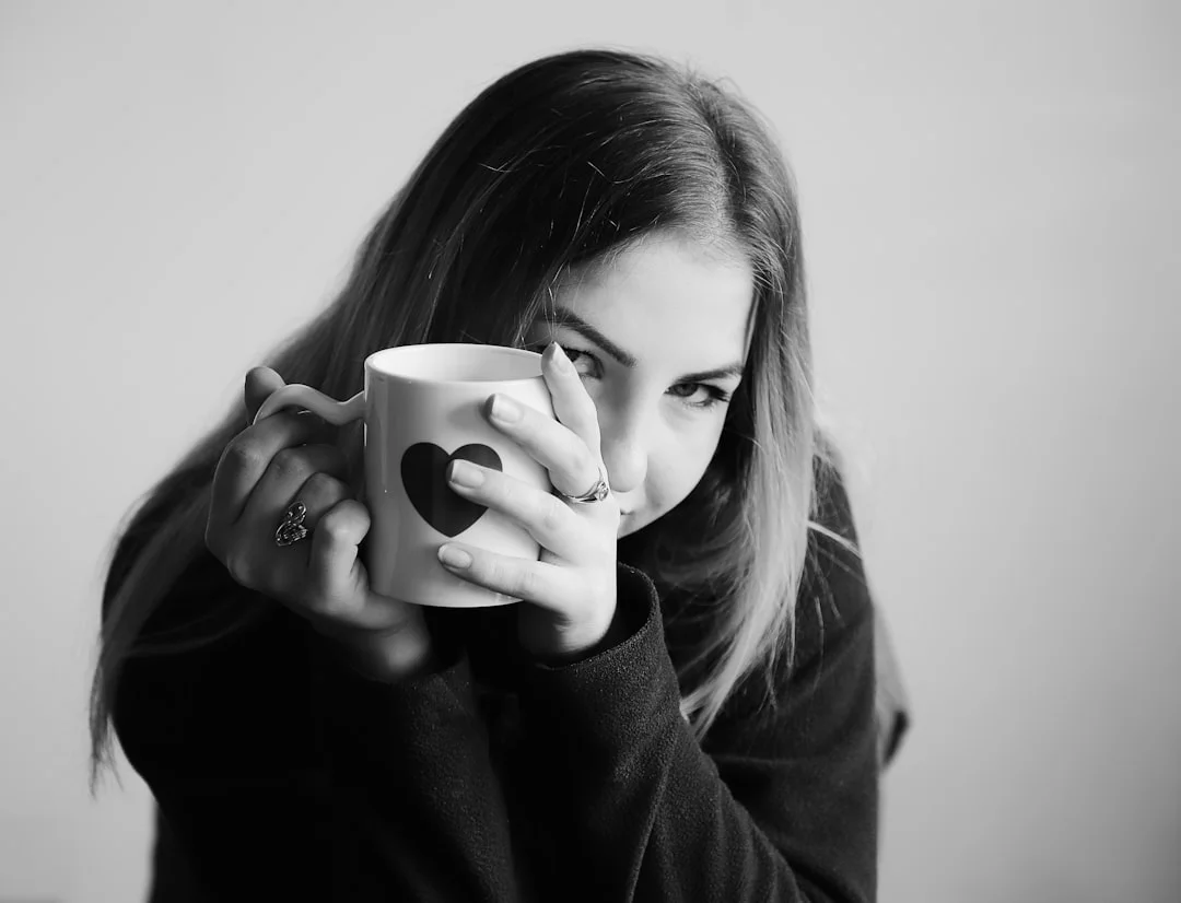 grayscale photo of woman holding ceramic mug